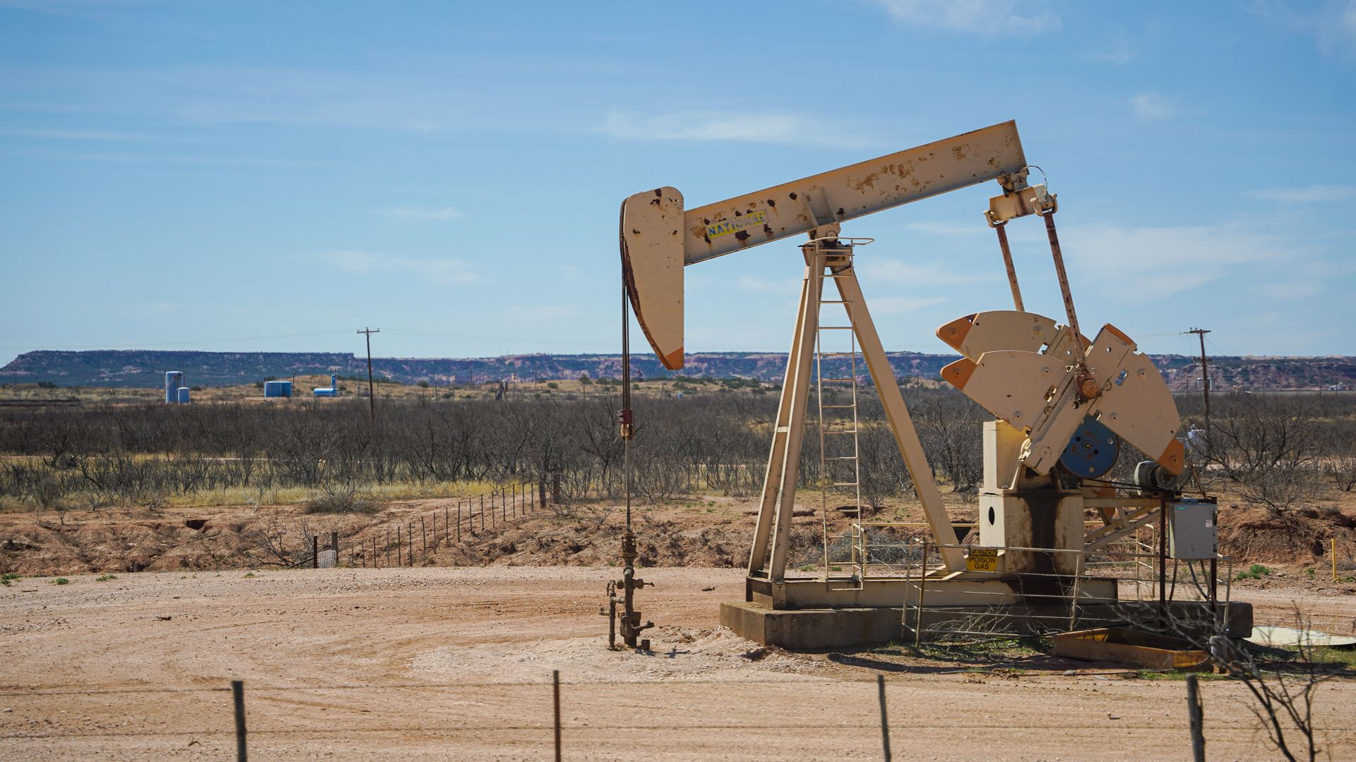Bomba de petróleo em campo de extração sob céu azul